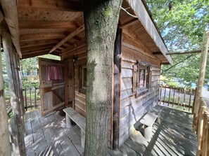 Eine Holzhütte mit Veranda, Bank und Tür.