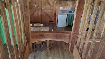 Een houten interieur met een keukenhoek, een eettafel en een trap.