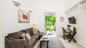 A living room with a sofa, coffee table, and a view of the outdoors. - Buendía Lux - Piña Suite. Retreat to enjoy the natural beauty of Costa Rica. (Potrero Beach, Tempate)