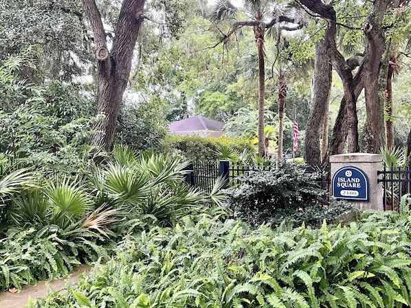A lush garden with a sign reading 'Island Square 2400'.