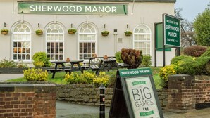 Sherwood Manor, a pub with a signboard, outdoor seating, and a welcome sign for the car park. - Comfy 2BR Flat on Hucknall Road (Nottingham)