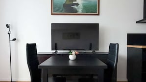 A modern dining area with a black table, four black chairs, a black floor lamp, and a framed painting of a sailboat on the wall. - Casa Sabotino, modern, functional, and cozy (Bologna)