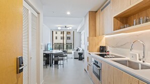 Eine moderne Küche mit Holzschränken, einer Marmorarbeitsplatte und einem eingebauten Backofen.