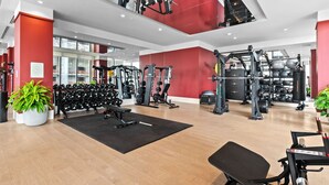 A modern gym with various exercise equipment, a black mat, and potted plants. - Rooftop Pool Studio in Miami Worldcenter (Miami)