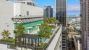 A high-rise building with a rooftop pool area, surrounded by other buildings and a view of the marina. - Rooftop Pool Studio in Miami Worldcenter (Miami)
