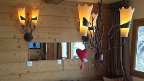 Ein gemütliches Zimmer mit einer Holzwand, einer Couch und einer hängenden Herzdeko.