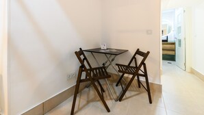 A small room with a table and two chairs, a whiteboard, and a door leading to another room. - M Iri70 Acogedor D Plex en el Barrio Salamanca (Madrid)