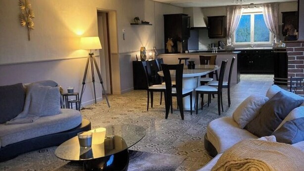 Un soggiorno con divano, tavolino e zona pranzo con sedie e tavolo.