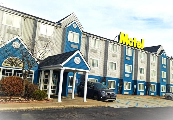 A motel with a blue and white exterior, a covered entrance, and a parking lot. - Budgetel Inn Birmingham (Birmingham)