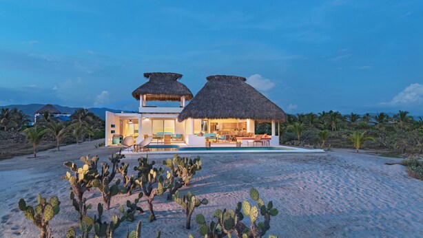 A beachfront property with a pool, thatched-roof structures, and cacti. - Casa Quetzal - Private beachfront villa - Swimming pool & total peace & quiet (Puerto Escondido)