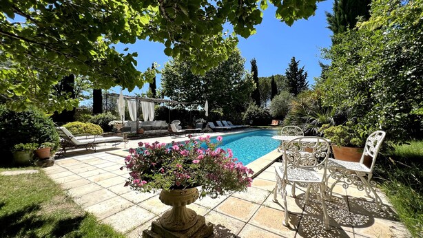 A pool area with lounge chairs, a table, and a flower pot. - Room “Apartment, Blue Room” with Shared Pool, Wi-Fi and Air Conditioning (Carpentras)