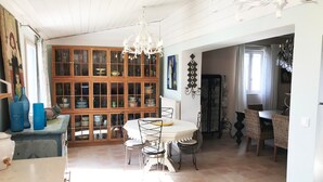 A spacious kitchen with a dining area, wooden cabinets, and a chandelier. - Room “Apartment, Blue Room” with Shared Pool, Wi-Fi and Air Conditioning (Carpentras)