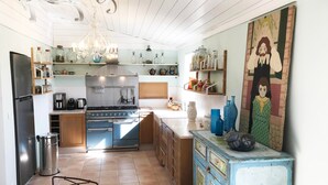 Une cuisine équipée d’une cuisinière, d’un réfrigérateur et de divers ustensiles de cuisine.
