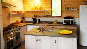 Une cuisine avec des lambris en bois, des appareils électroménagers en acier inoxydable et une fenêtre offrant une belle vue.