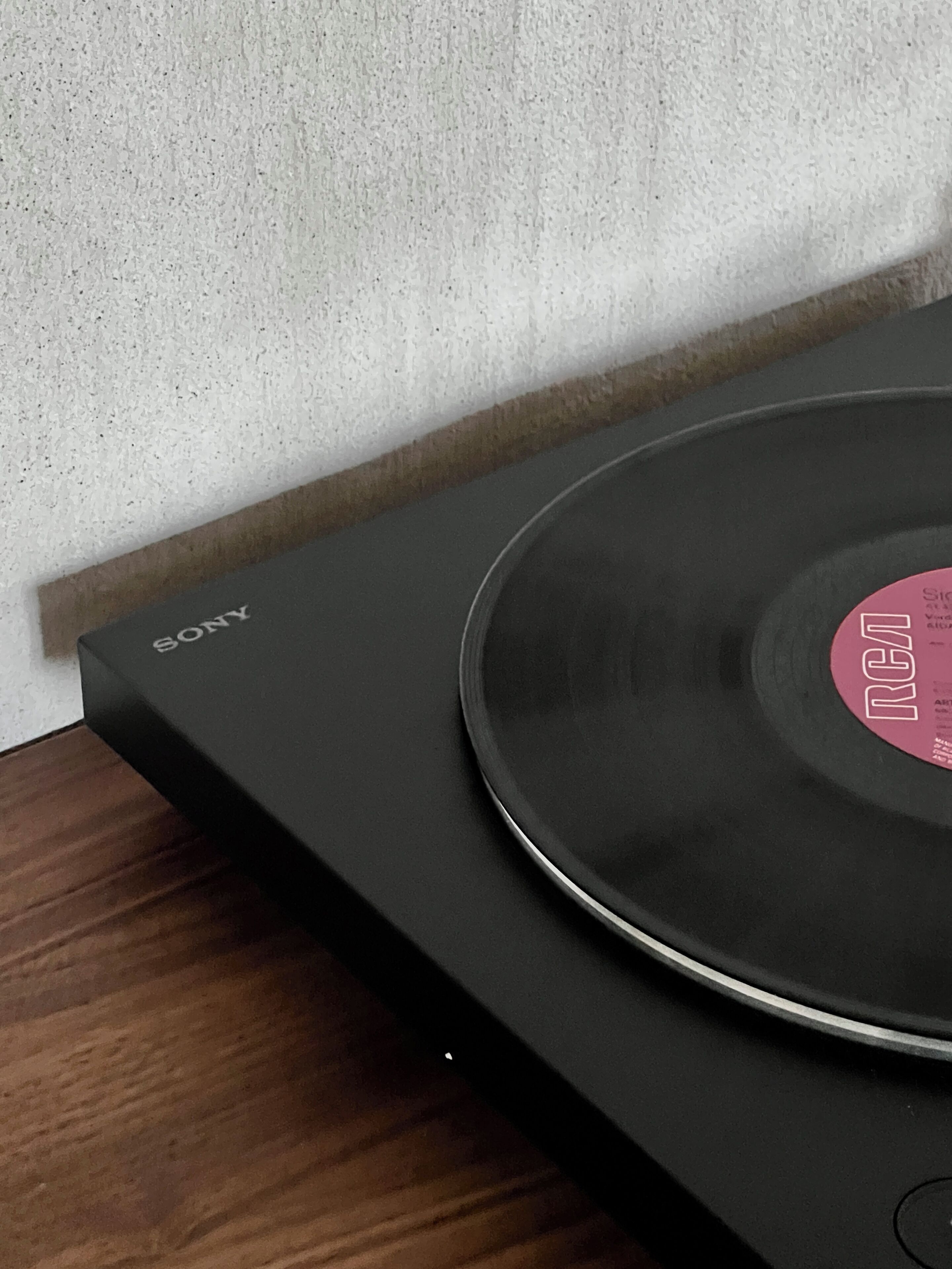 Une platine vinyle avec un disque en vinyle posé dessus, placée sur une surface en bois.