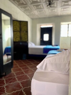 Una habitación de hotel con cama, armario y espejo.