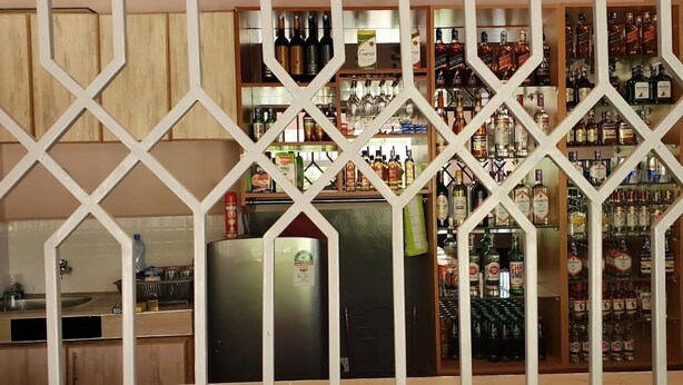Een bar met verschillende drankflessen en glazen.