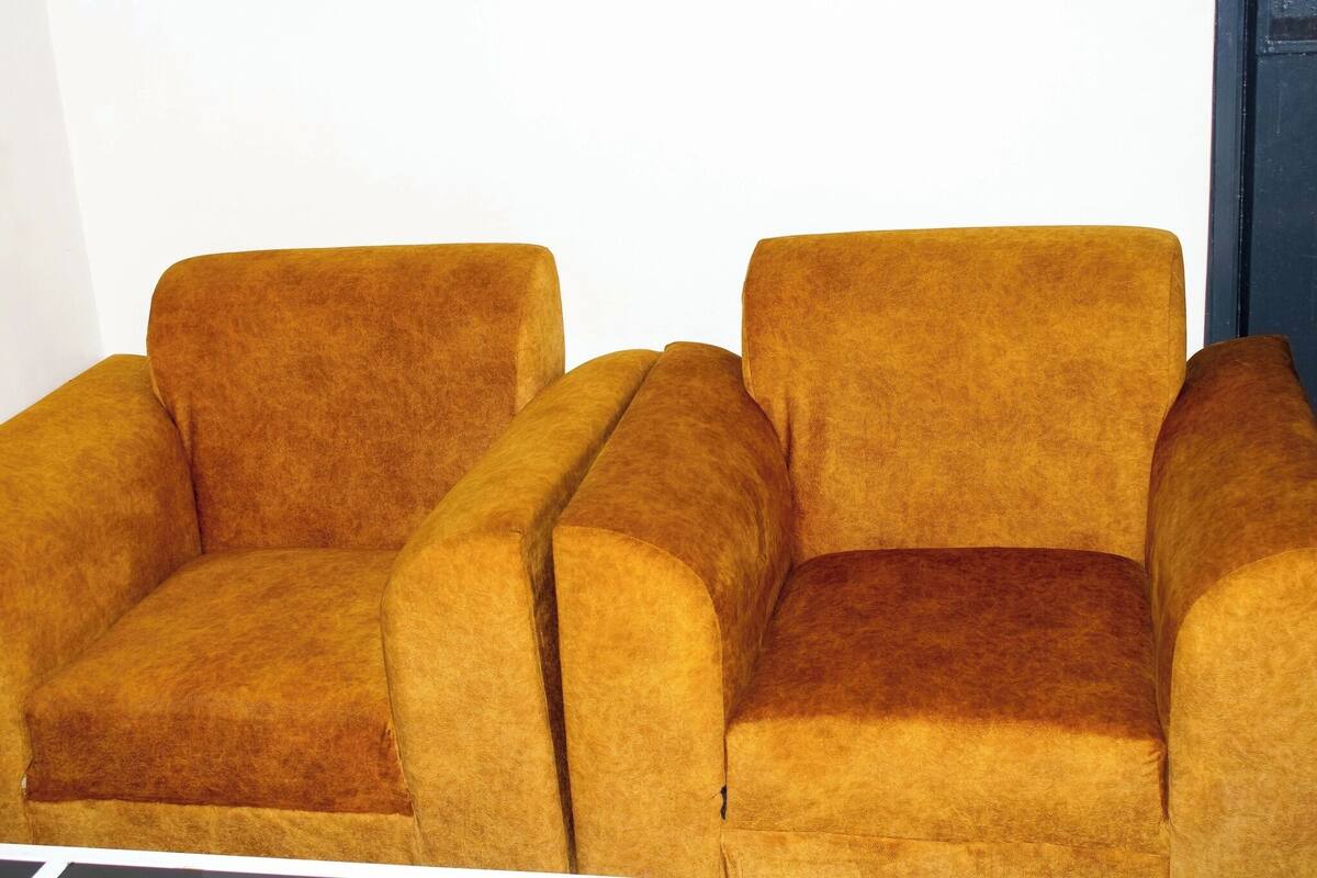 Twee fauteuils met een stevige, warme stofkleur.