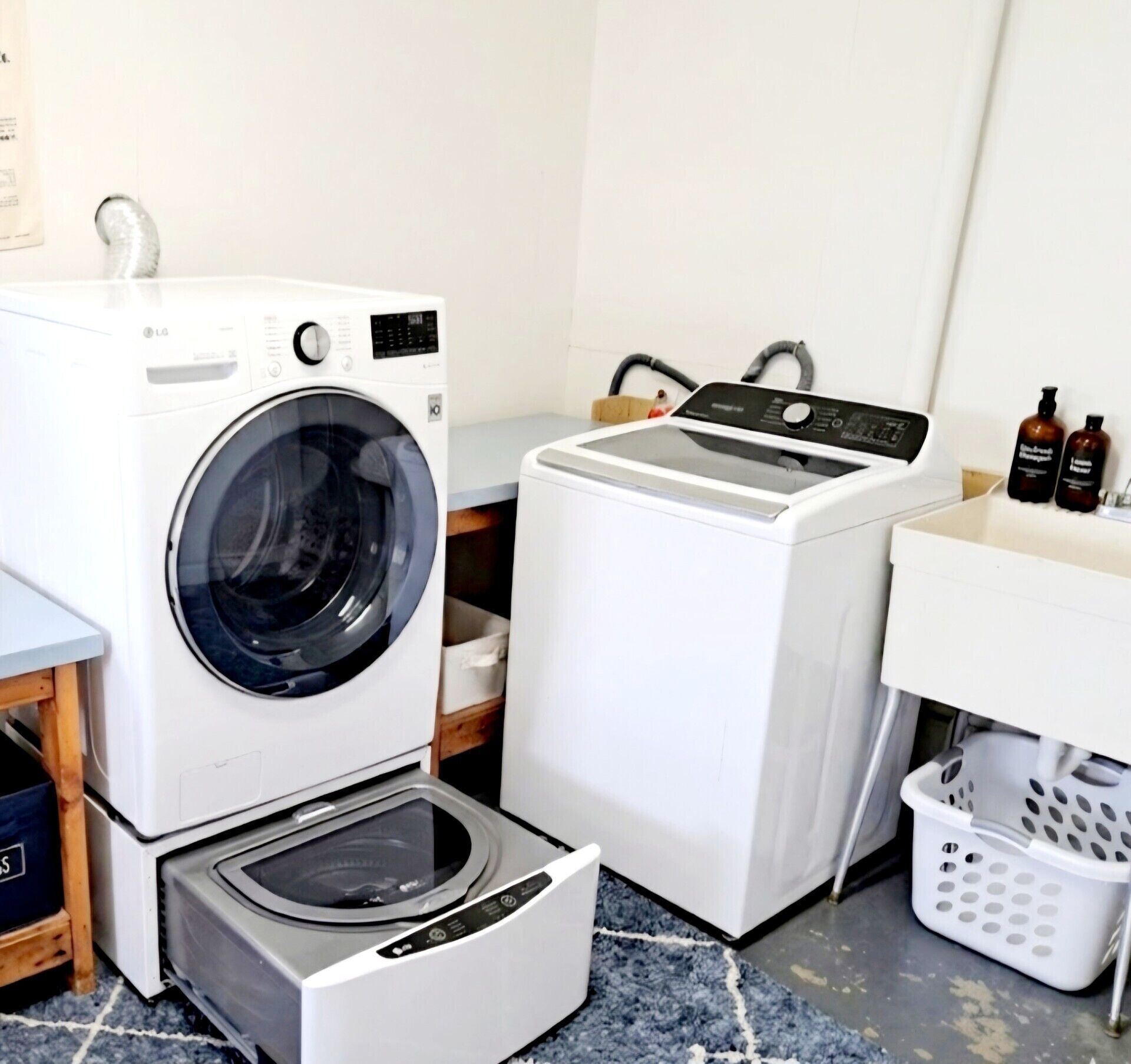 A laundry area with a front-loading washer, a stacked dryer, and a washing machine.