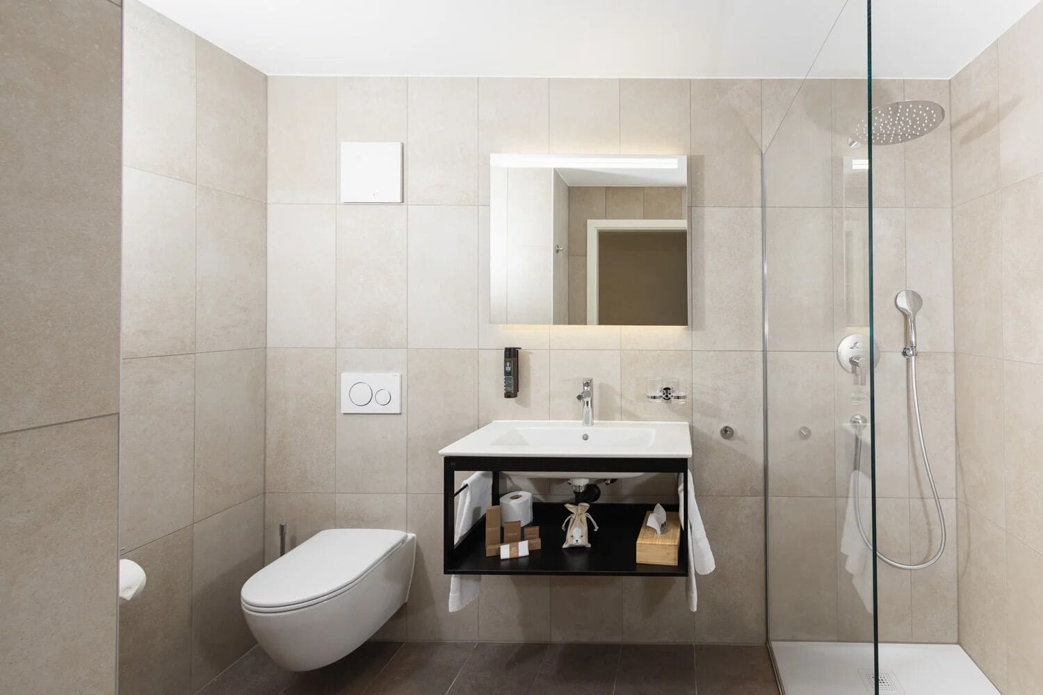 A modern bathroom with a toilet, sink, and shower.