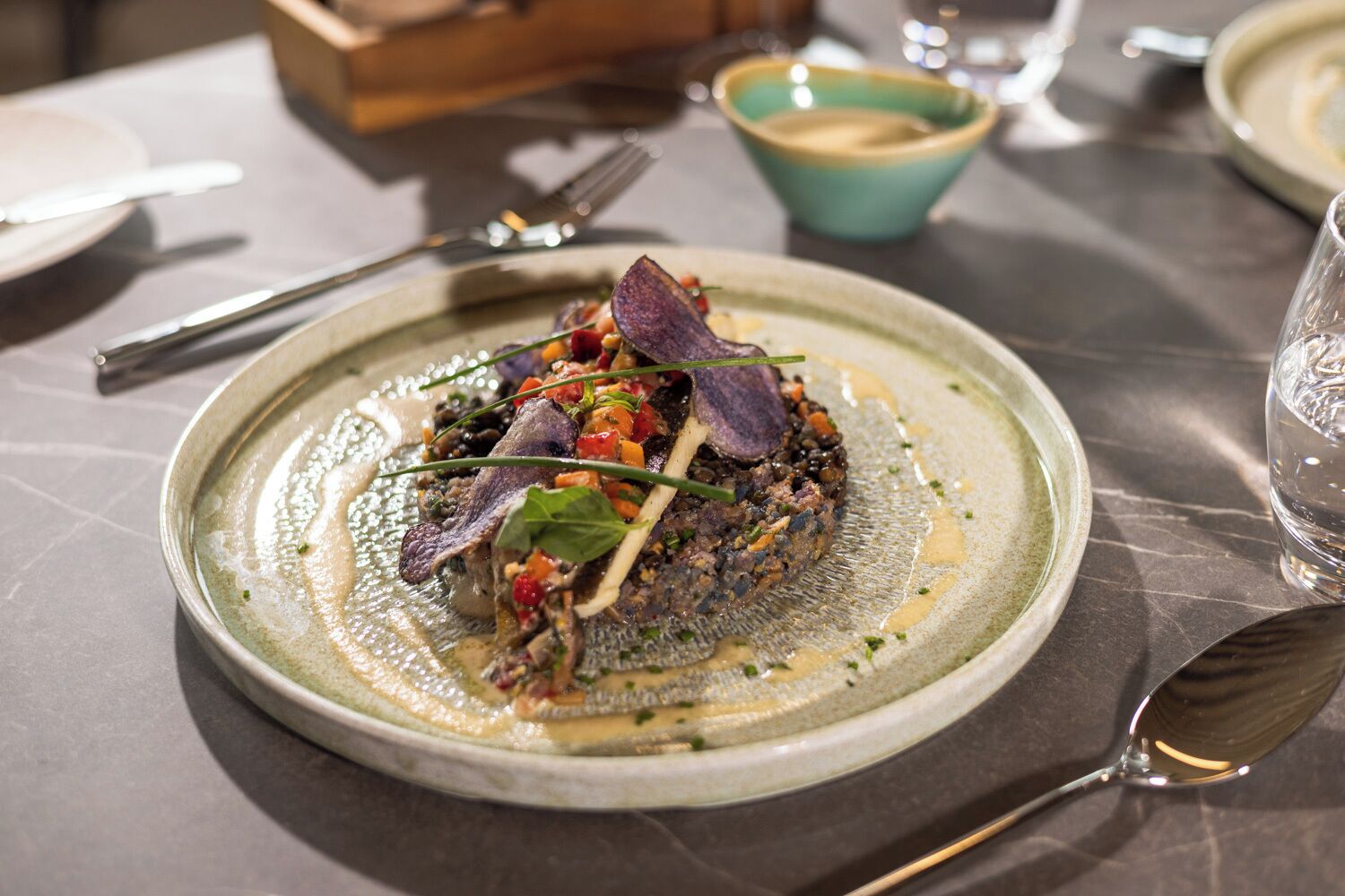 A plate of food with a fork and spoon on the table.