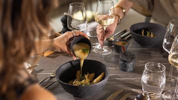 A dining table with bowls, wine glasses, and cutlery.