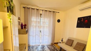 A living room with a sofa, a patterned rug, a staircase, and a plant. - Cinecittà Family House metro A - Rome Collection  Metro A Cinecittà Roma (Roma)