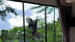 A bedroom with a large window, a bed, and a hanging light fixture. - Lovely 2-bedroom villa with AC in beautiful Ubud Bali (Bali)