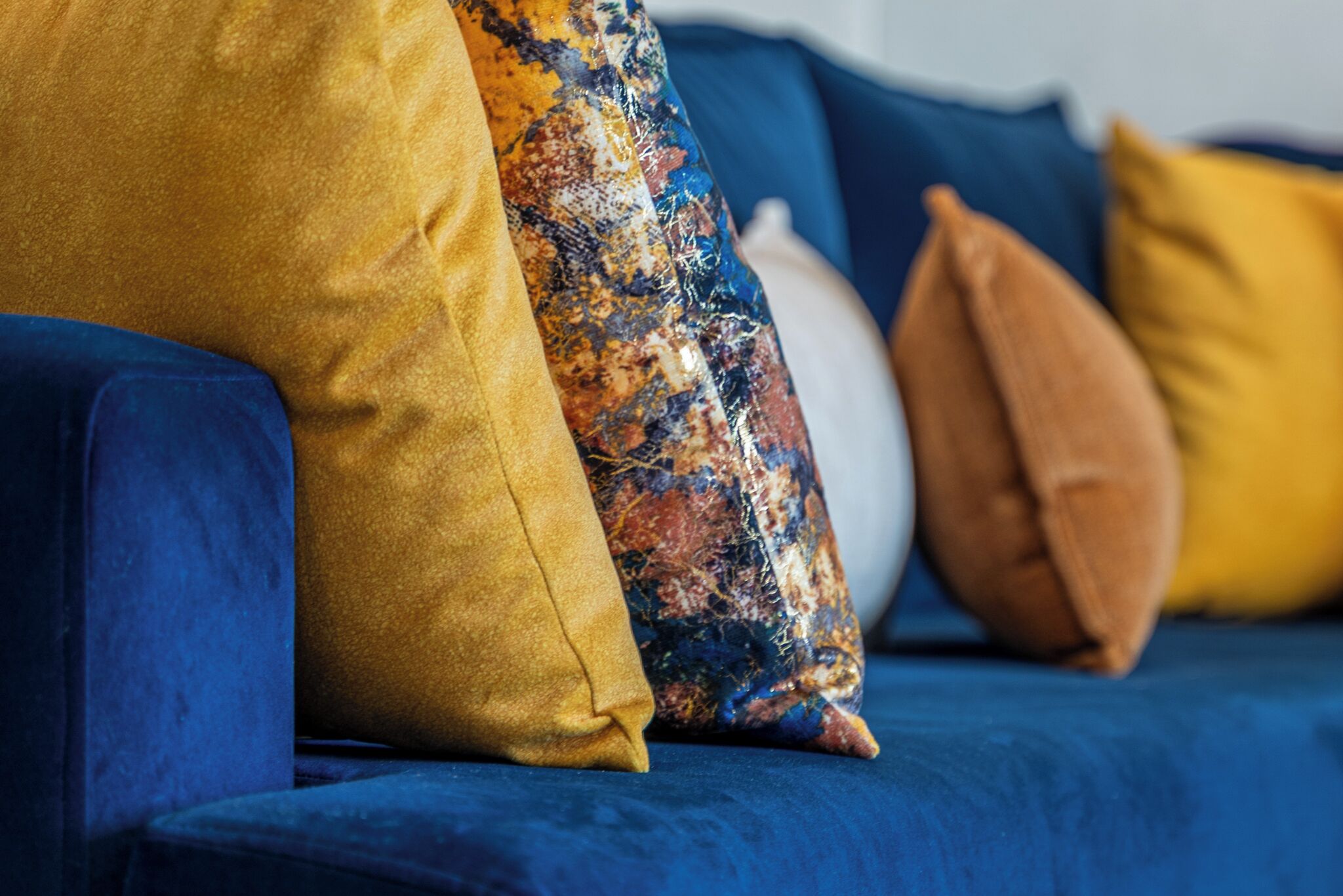 Un canapé bleu agrémenté de plusieurs coussins de différentes couleurs.