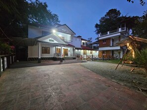 A courtyard with a paved walkway leading to a building with a balcony.