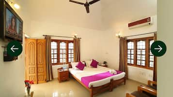 A hotel room with a bed, bedside tables, a TV, and curtains.
