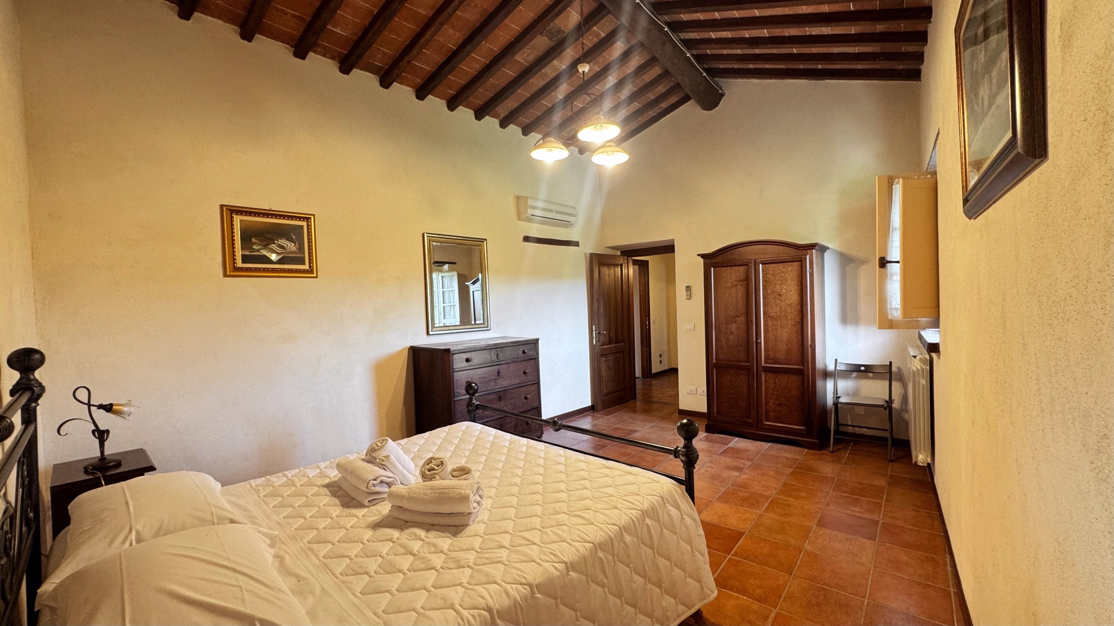 Un dormitorio con cama, cómoda, espejo y armario.