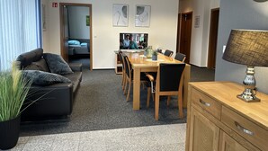 Un espace de bureau moderne comprenant une table de conférence, des chaises, un canapé et une lampe.