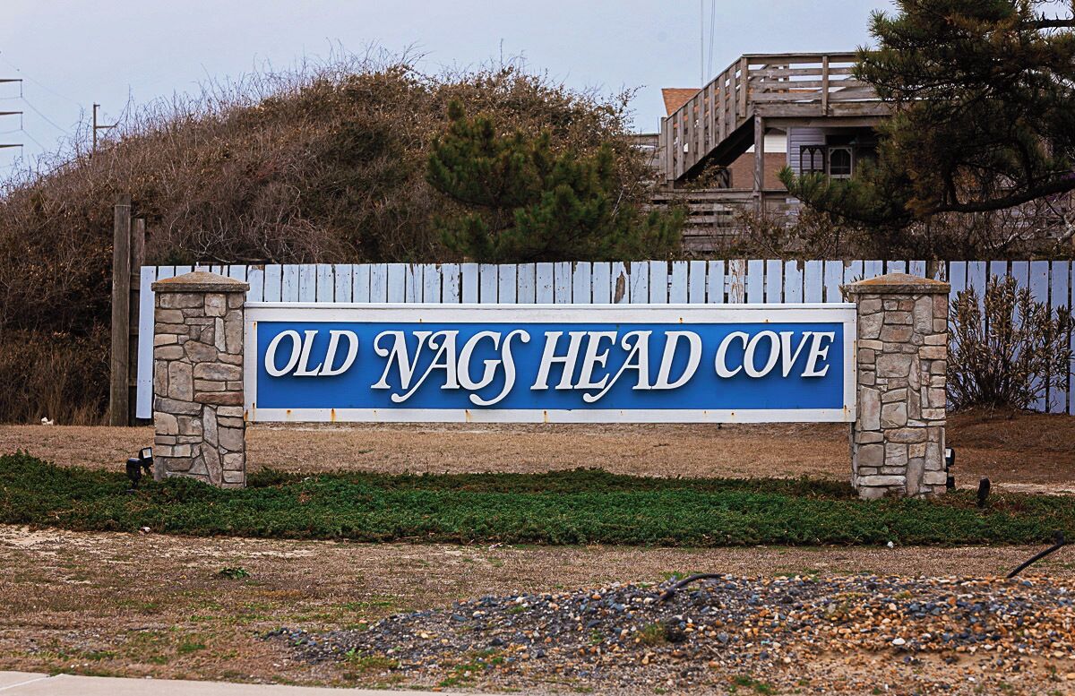 Een bordje voor Old Nags Head Cove, met een houten hek en stenen pilaren.