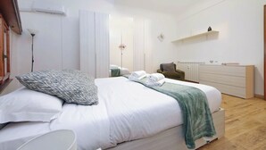 Ein modernes Schlafzimmer mit einem großen Bett, einem Nachttisch, einer Kommode und einem Kleiderschrank.