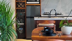 A modern kitchen with a built-in microwave, refrigerator, and gas stove. There is a dining table with chairs and a hanging light fixture above. - Marvelous 3-bedroom villa with AC in vibrant Ubud Bali (Bali)