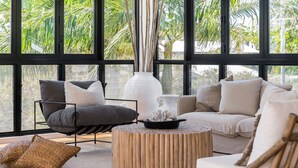 A modern living room with a sofa, armchair, and round wooden coffee table.