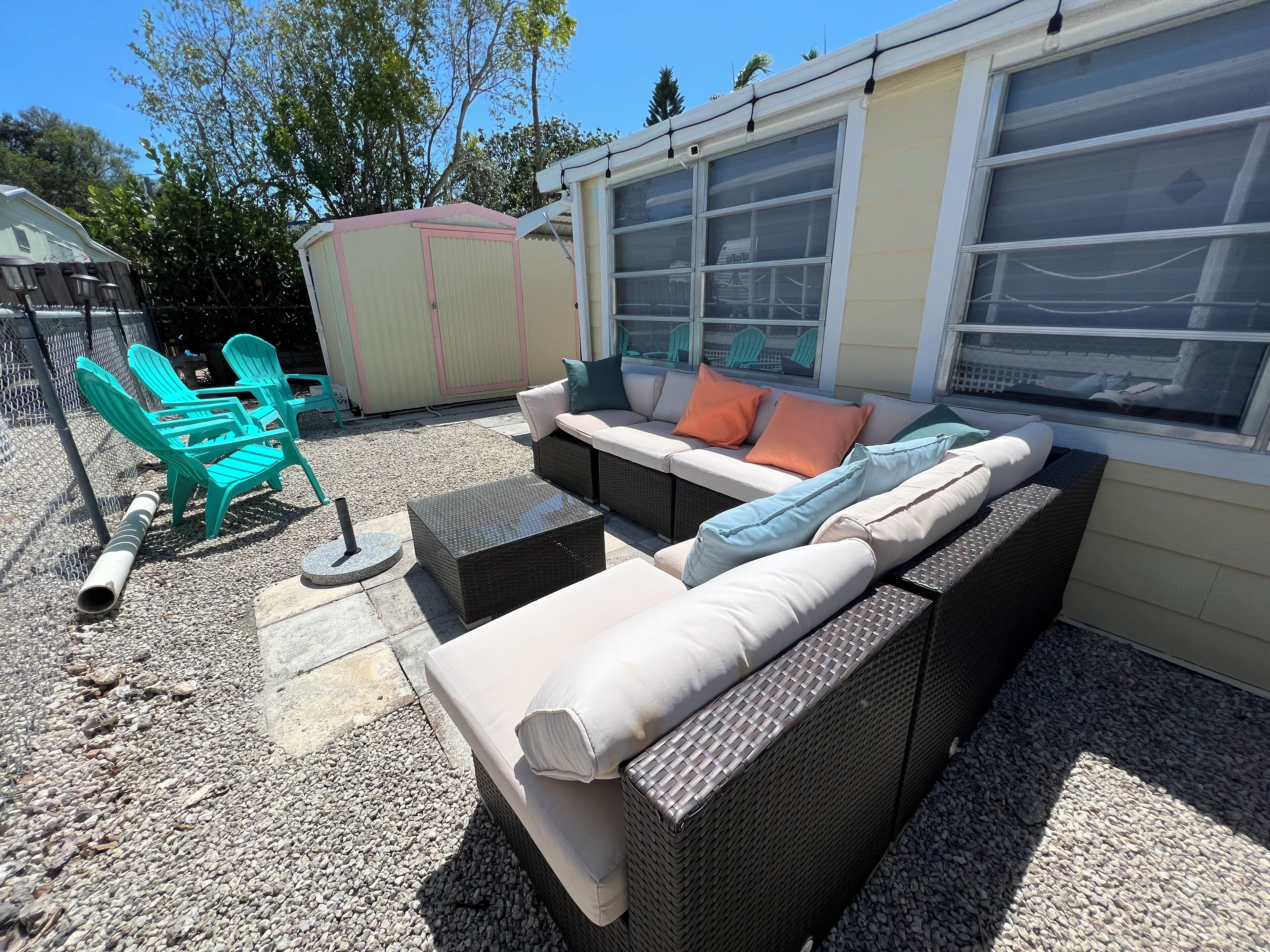 A patio area with outdoor furniture, including a sofa and chairs, and a covered play area.
