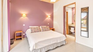 Een slaapkamer met een bed, twee nachtkastjes, een wandlamp en een spiegel.