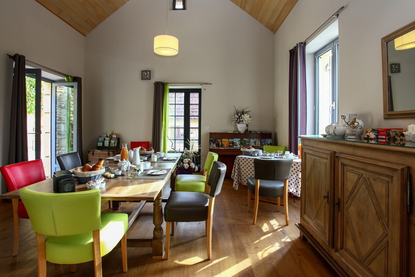 Un coin repas comprenant une table en bois, des chaises et un buffet.