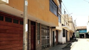 A narrow street with buildings on both sides, featuring a mix of residential and commercial properties. - Fenced apartment (additional garage) (San Salvador)