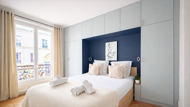 Une chambre moderne avec un grand lit, une vue sur la ville et un balcon.