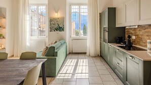 Een moderne keuken met een eethoek, grote ramen en uitzicht op de bergen.