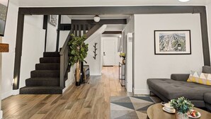 Una sala de estar moderna con una escalera, un sofá y una mesa de centro.