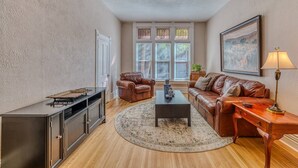 Ein Wohnzimmer mit einem braunen Ledersofa, einem Couchtisch und einem Schrank.