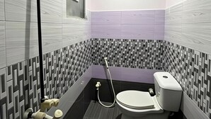 A modern bathroom with a shower, toilet, and a window.