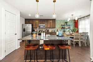 A modern kitchen with granite countertops, stainless steel appliances, and wooden bar stools. - BBQ, Workspace, Near Austin Peay & Fort Campbell (Clarksville)