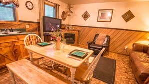 Un accogliente soggiorno con un tavolo da pranzo in legno, un camino e un divano in pelle.