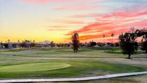 Un terrain de golf avec un ciel dégagé et un coucher de soleil.