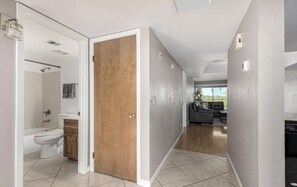 A modern apartment with a bathroom, a wooden door, and a living area with a sofa and a view. - Amazing golf course and sunset views in Old Town Scottsdale (Scottsdale)